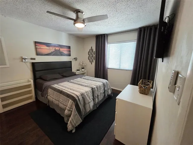 a bedroom with a bed a flat screen tv and a window