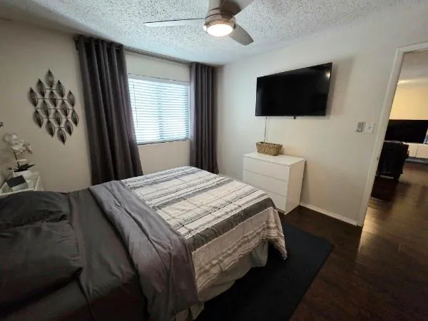 a bedroom with a bed and a flat tv screen on the dresser