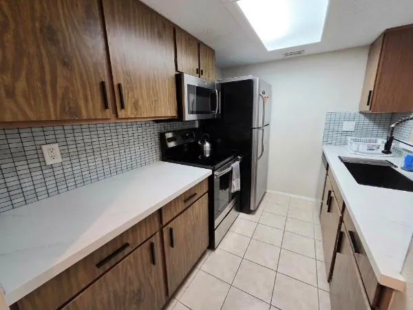 a kitchen with a sink a stove top oven and refrigerator