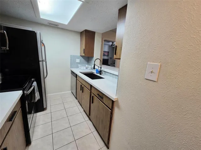 a kitchen with stainless steel appliances a sink stove and refrigerator