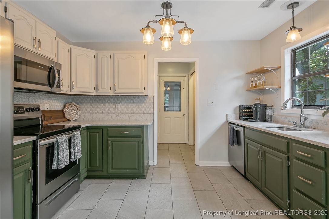 64 California Lane Spring Lake, NC 28390 - Photo 18 of 50 a kitchen with stainless steel appliances granite countertop a stove and a sink