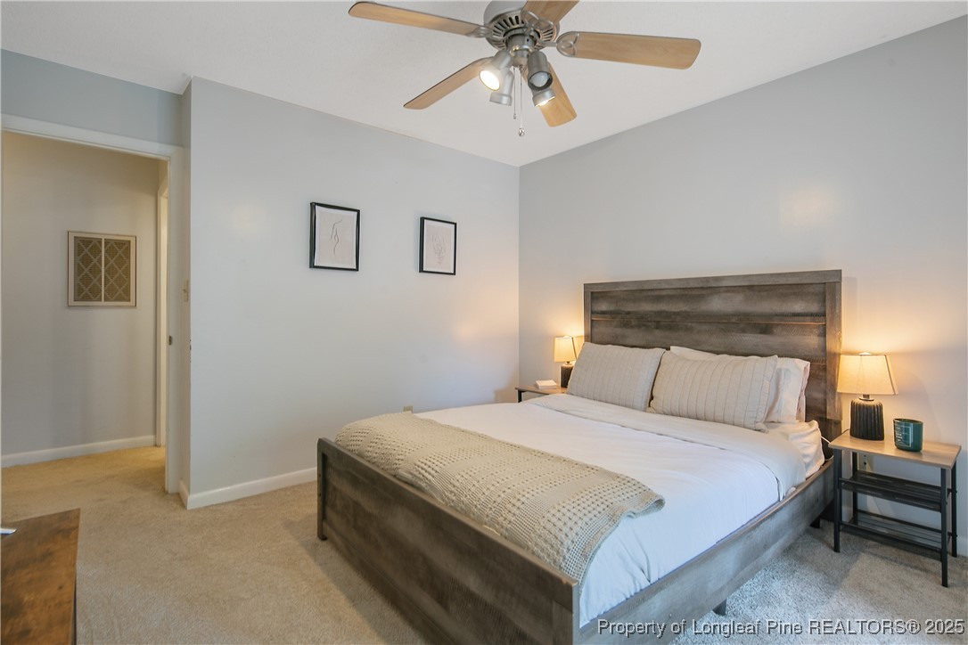 64 California Lane Spring Lake, NC 28390 - Photo 42 of 50 a bedroom with a bed and a chandelier