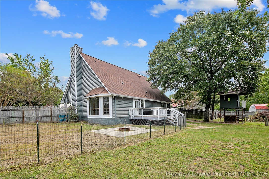 64 California Lane Spring Lake, NC 28390 - Photo 44 of 50 a house view with swimming pool and trees in the background