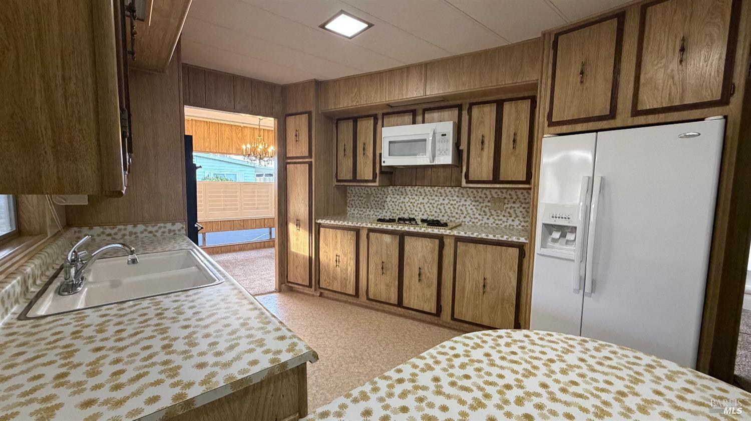 145 Stratford Way Santa Rosa, CA 95401 - Photo 18 of 48 a kitchen with stainless steel appliances granite countertop a refrigerator a stove and white cabinets with wooden floor