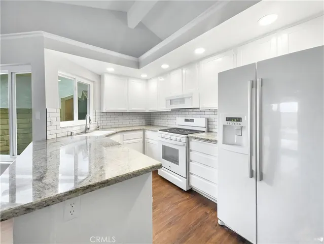 a kitchen with white cabinets and white appliances