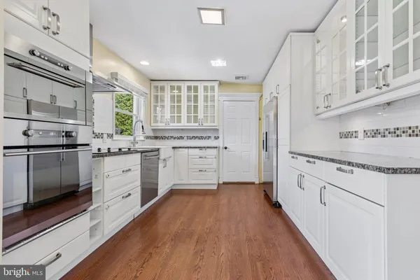 a kitchen with granite countertop white cabinets and white appliances