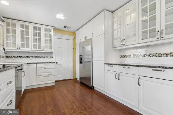 a kitchen with stainless steel appliances granite countertop a refrigerator and a stove top oven