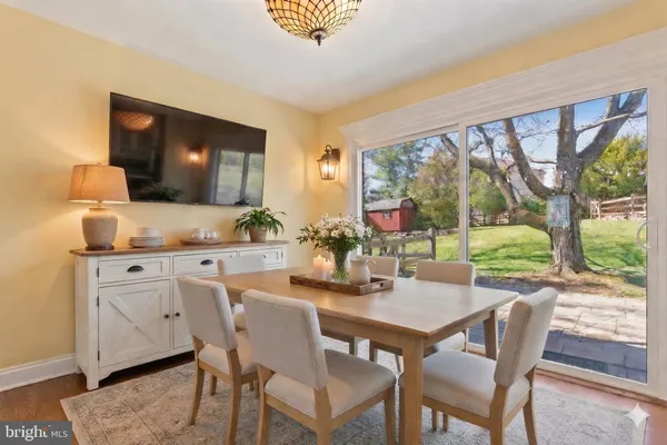 a view of an empty room and kitchen with furniture wooden floor and windows