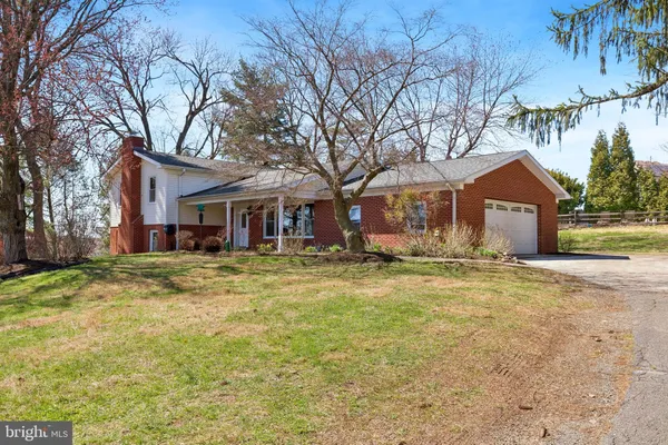 a front view of house with yard and trees around