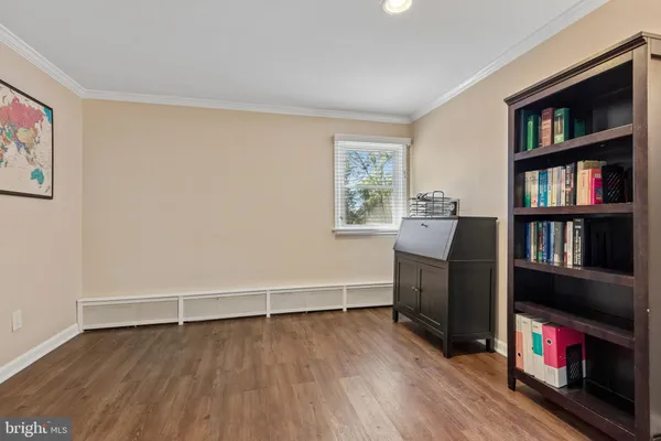 a spacious bedroom with a bed a couch and potted plant on the dresser