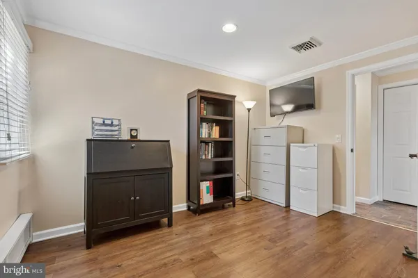 a view of an empty room with wooden floor and closet