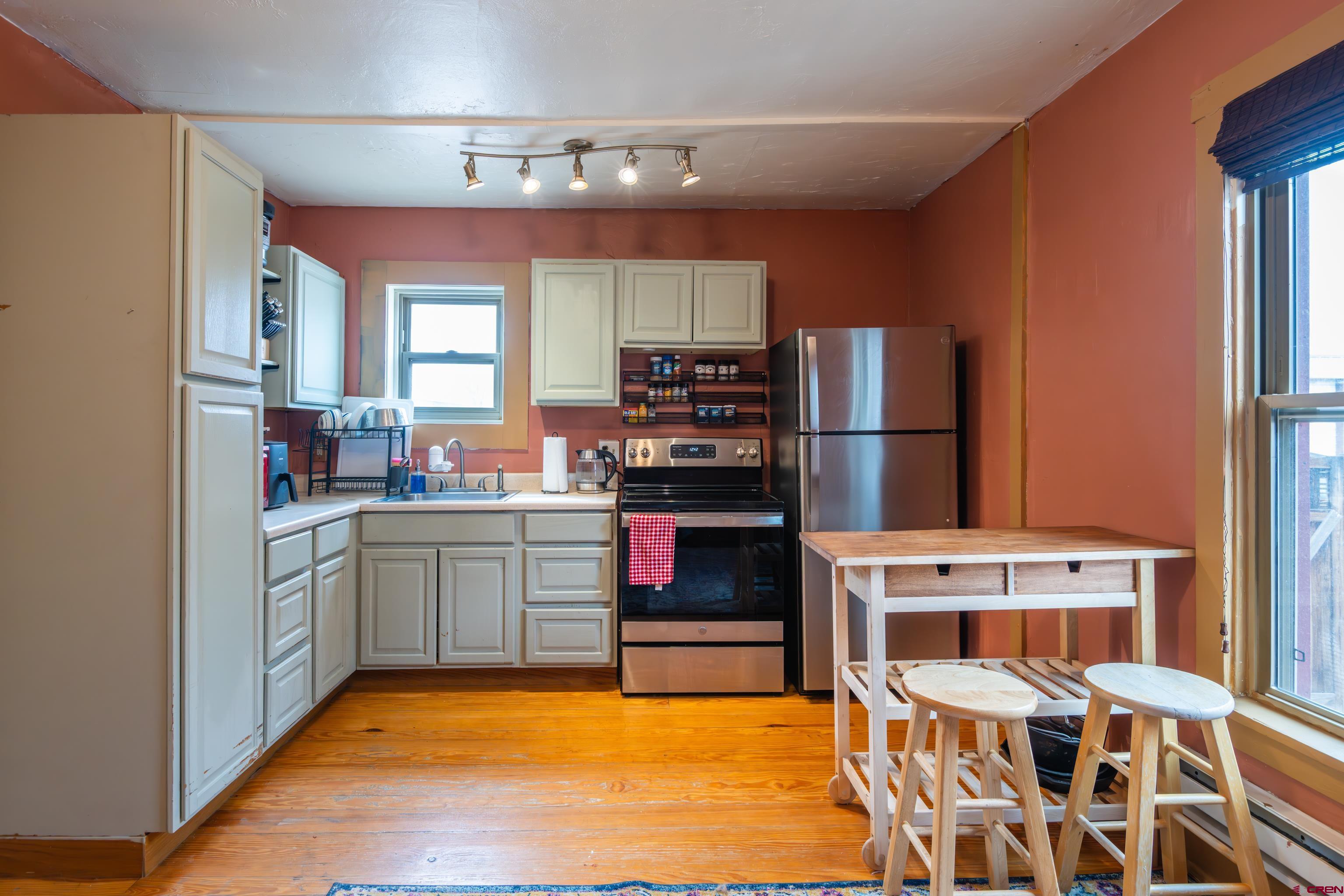 101 North 10th Street, Unit 2 Gunnison, CO 81230 - Photo 16 of 28 a kitchen with stainless steel appliances kitchen island granite countertop a refrigerator and a stove top oven