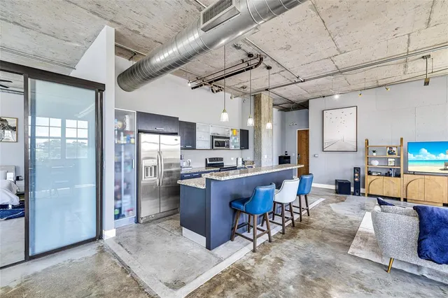 a large open kitchen with stainless steel appliances granite countertop a refrigerator and cabinets