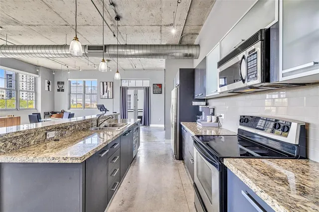 a kitchen with stainless steel appliances granite countertop a sink and stove