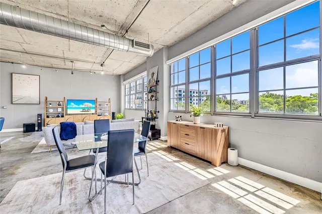 a dining room with furniture a kitchen view and wooden floor