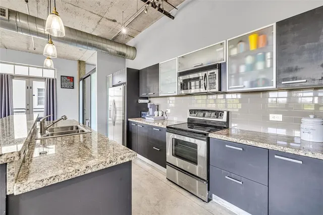 a kitchen with stainless steel appliances granite countertop a sink stove and cabinets