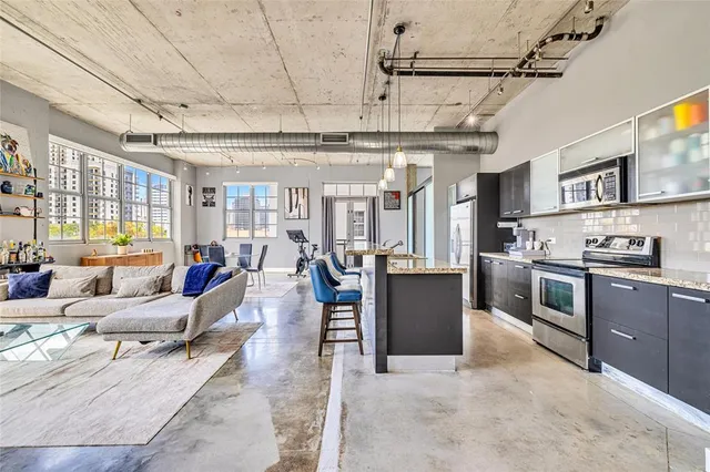 a living room with stainless steel appliances granite countertop lots of counter top space