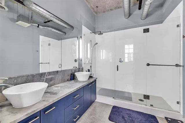 a bathroom with a granite countertop sink a toilet a mirror and shower
