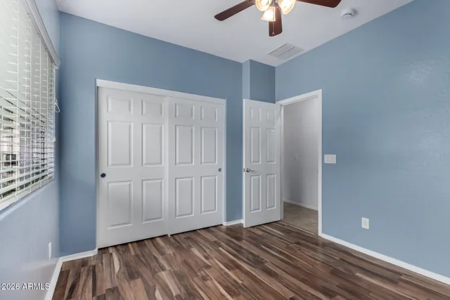 wooden floor in an empty room with a chandelier fan