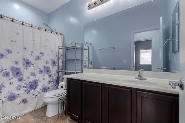 a bathroom with a granite countertop sink a toilet and a mirror