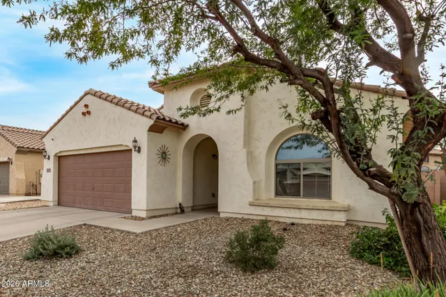 a view of a white house with a large tree