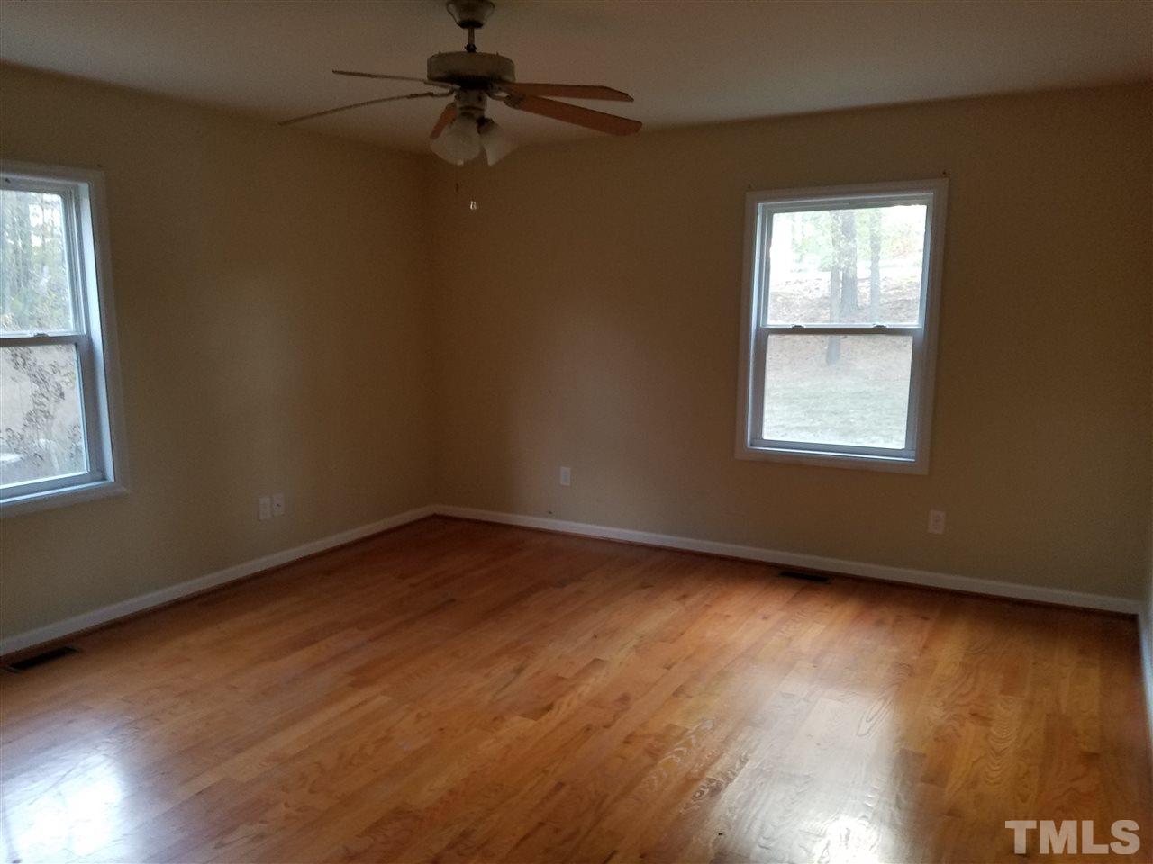760 Bill Avery Road Coats, NC 27521 - Photo 4 of 14 an empty room with wooden floor and windows