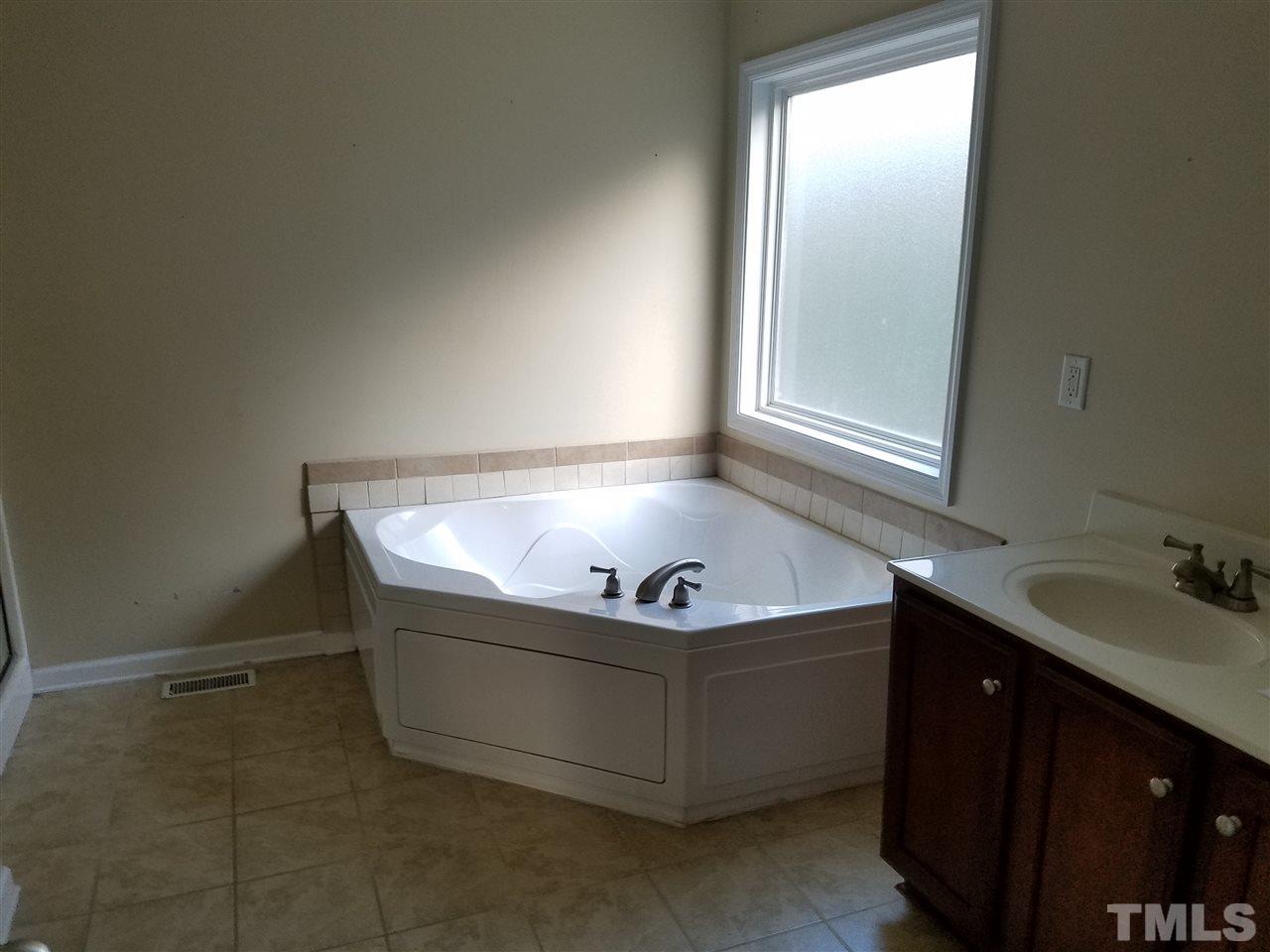 760 Bill Avery Road Coats, NC 27521 - Photo 5 of 14 a bath tub sitting in a bathroom next to a sink