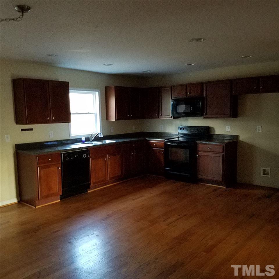 760 Bill Avery Road Coats, NC 27521 - Photo 8 of 14 a kitchen with stainless steel appliances granite countertop wooden cabinets a sink a stove a microwave and wooden floors