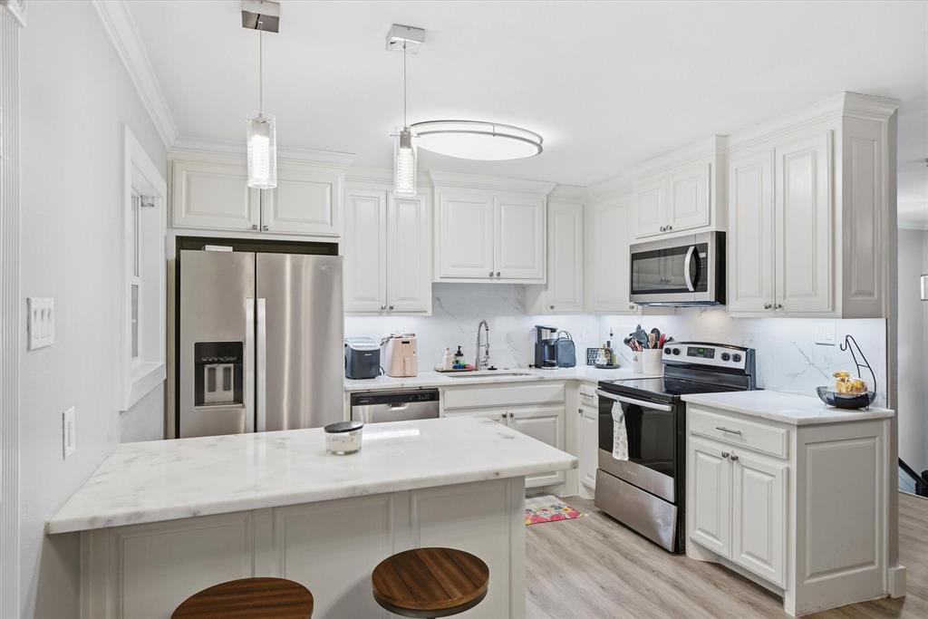 2422 Old Omen Road Tyler, TX 75701 - Photo 16 of 39 a kitchen with a sink a stove a refrigerator and chairs
