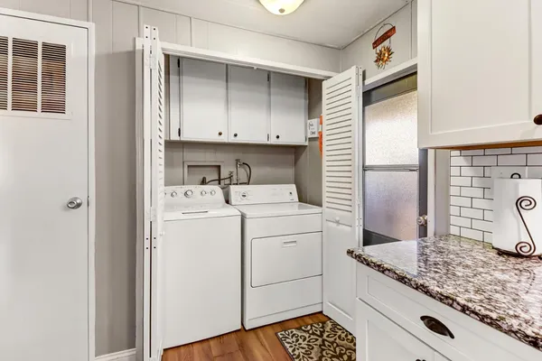 a utility room with cabinets washer and dryer