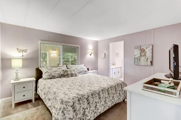 a bedroom with a bed and a tv on the dresser