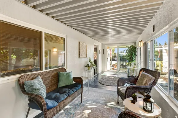 a living room with furniture and floor to ceiling windows
