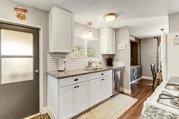 a kitchen with granite countertop a sink stainless steel appliances and cabinets