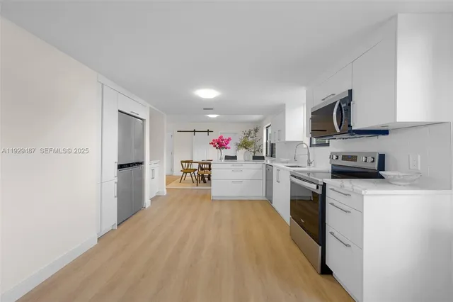 a kitchen with stainless steel appliances granite countertop a stove cabinets and a refrigerator