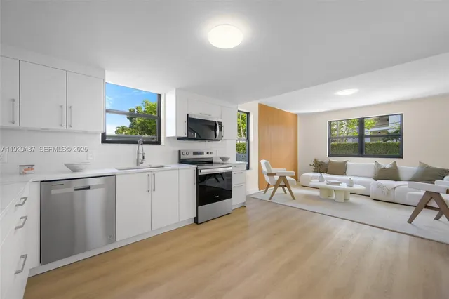 a living room with furniture a fireplace a flat screen tv and windows