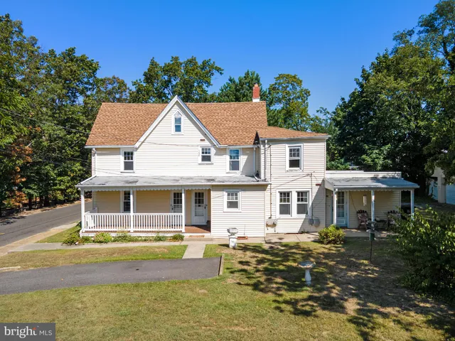 an aerial view of residential house with outdoor space and trees all around