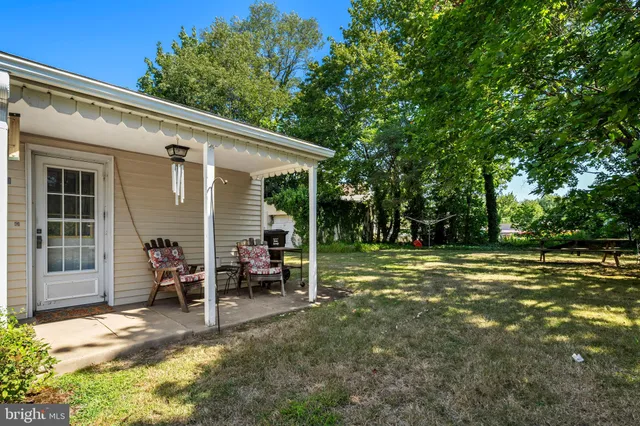 an aerial view of residential house with outdoor space and trees all around