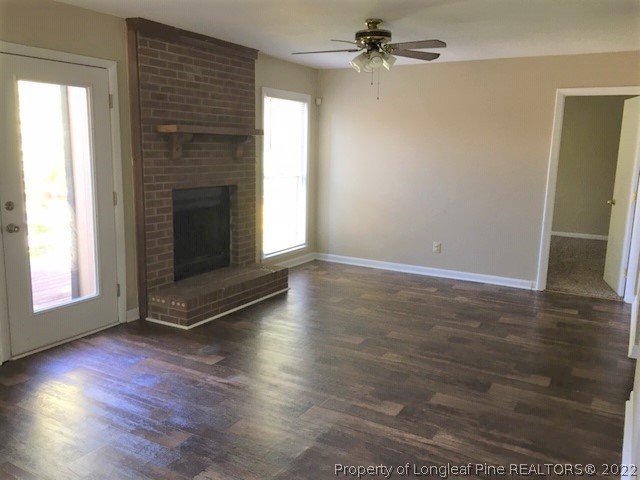 3319 Arrowhead Road Spring Lake, NC 28390 - Photo 4 of 20 an empty room with wooden floor fireplace and windows