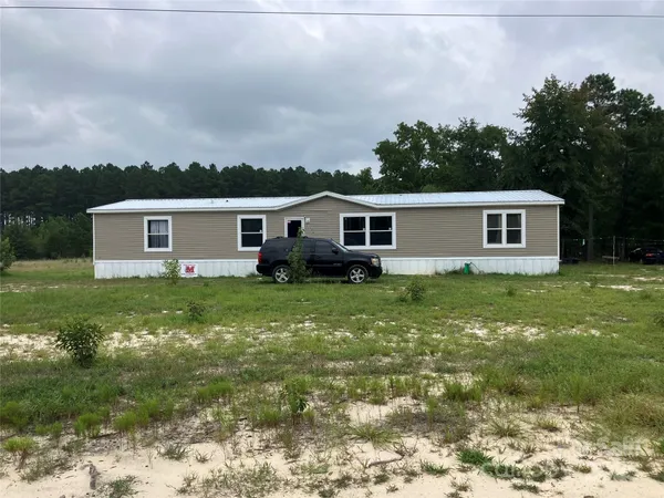 a view of a house with a backyard