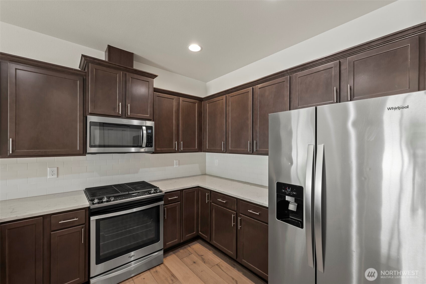 1080 East Old Ranch Road, Unit A1A2 Allyn, WA 98524 - Photo 13 of 35 a kitchen with granite countertop stainless steel appliances and wooden cabinets
