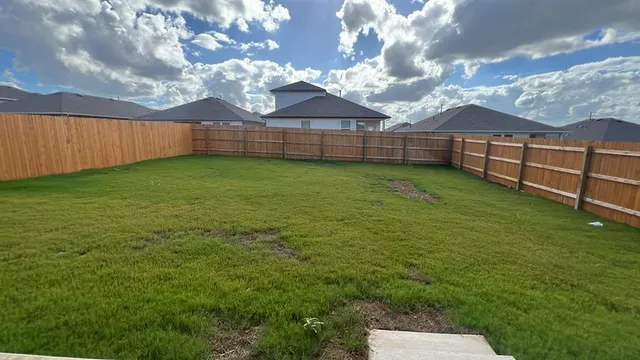 a view of backyard with wooden fence