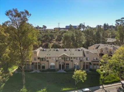 a view of a big house with a big yard and large trees