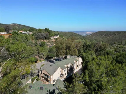 an aerial view of a house with a mountain