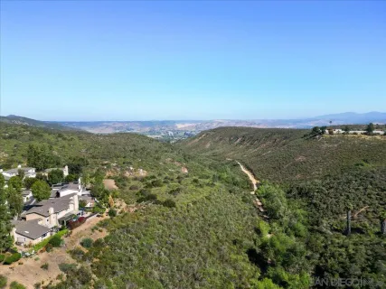 an aerial view of residential houses with outdoor space and trees