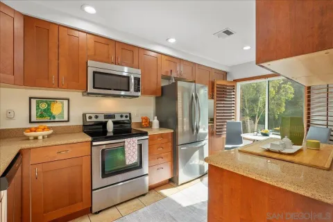 a kitchen with stainless steel appliances granite countertop a stove a sink and a refrigerator
