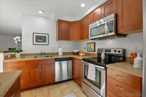 a kitchen with stainless steel appliances granite countertop a stove top oven a sink dishwasher and a microwave oven on the blue kitchen countertops