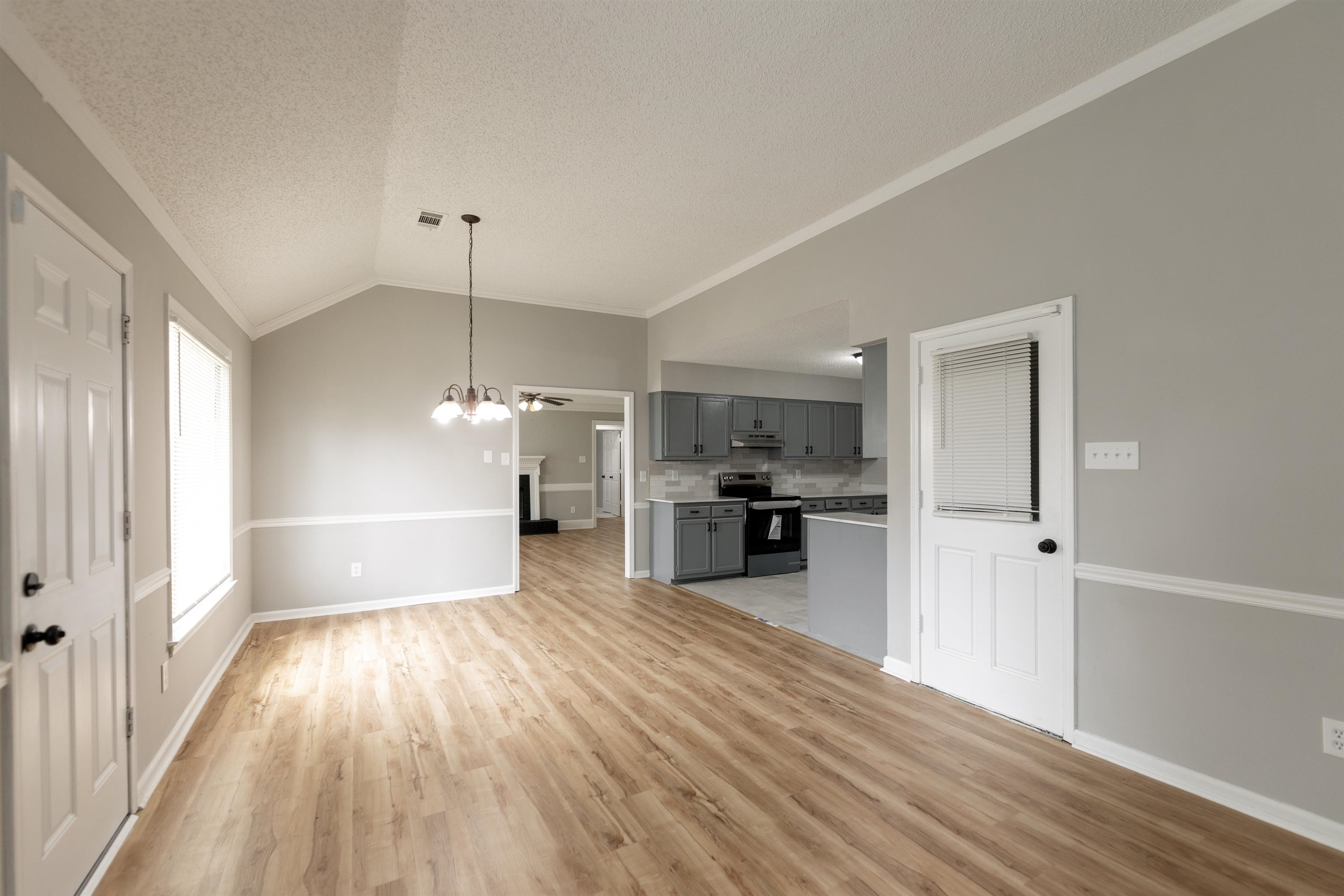 7421 Richmond Road Memphis, TN 38125 - Photo 12 of 39 Spacious room featuring wood-finish flooring, vaulted ceiling, and chair rail molding