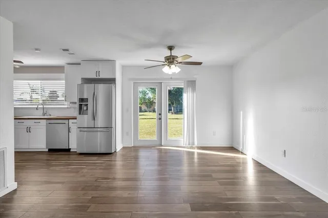 a kitchen with stainless steel appliances a refrigerator and wooden floor
