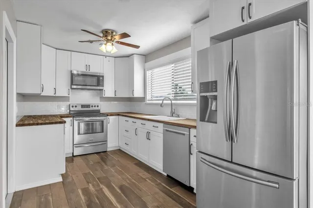 a kitchen with stainless steel appliances a refrigerator sink and microwave