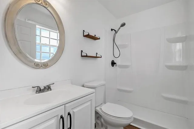 a bathroom with a sink a toilet and a mirror